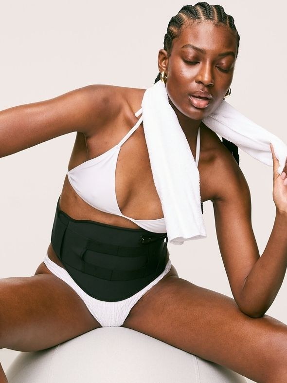 Model wearing a Solaris body therapy belt in a clean studio setting