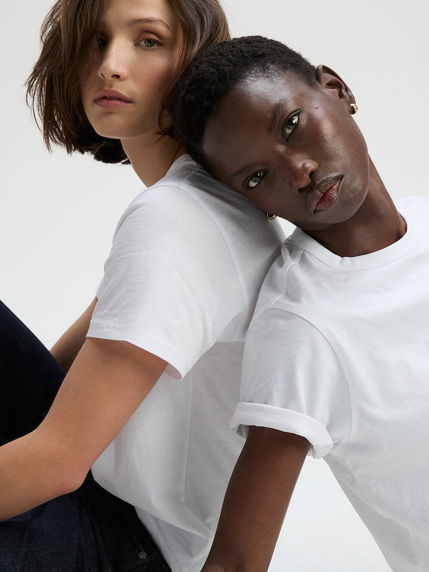 Two models wearing white T-shirts in a close studio portrait