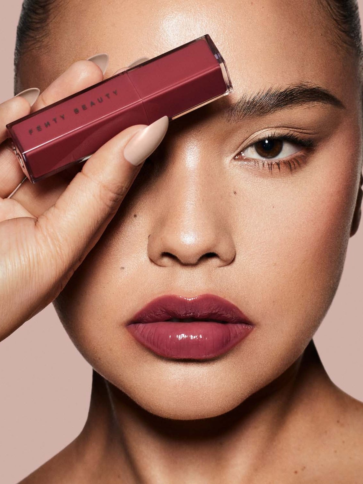 Close portrait with berry glossy lips holding a Gloss Bomb Stix
