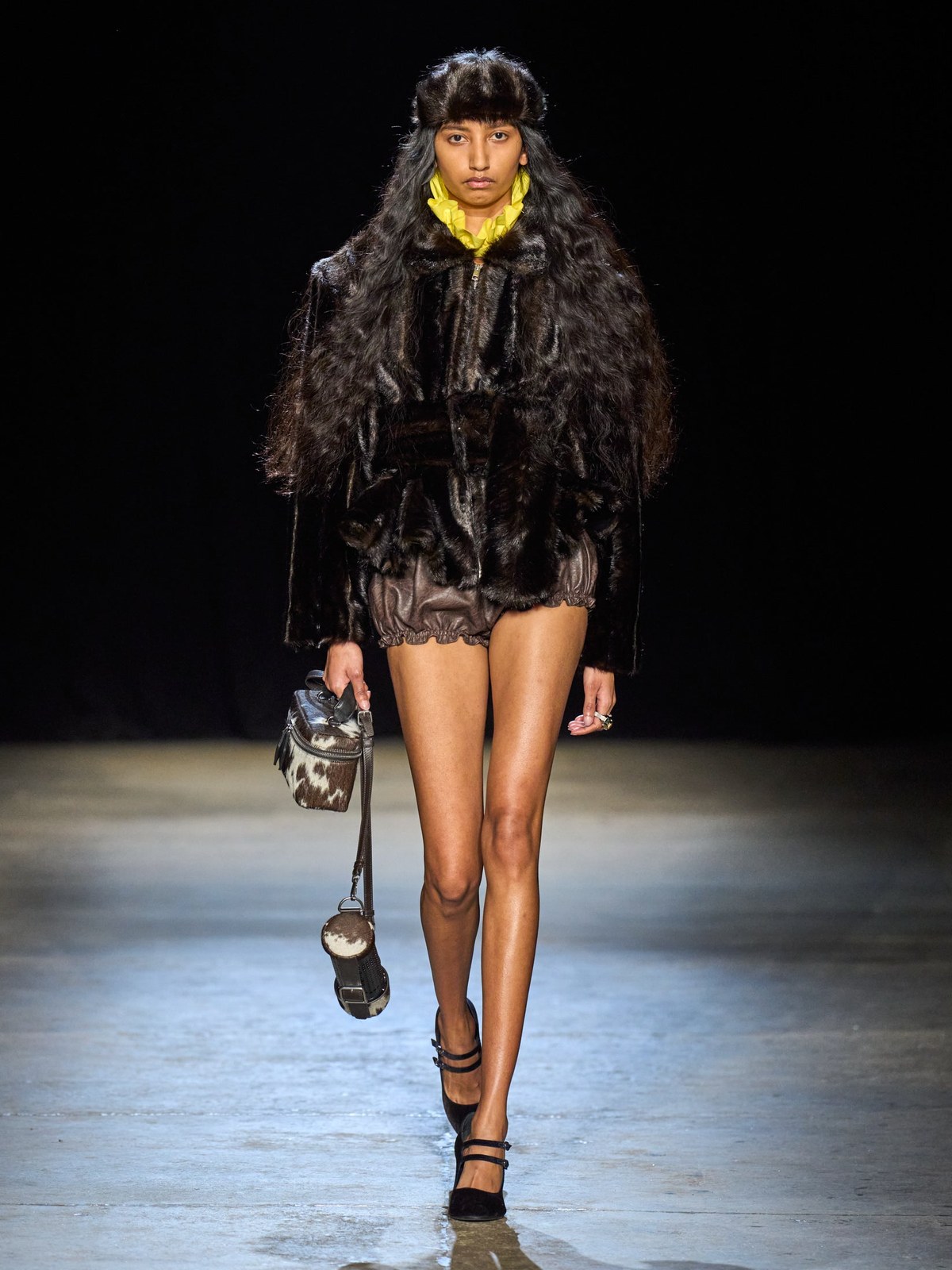 Model in dark faux-fur outerwear on the AKNVAS Fall 2026 runway