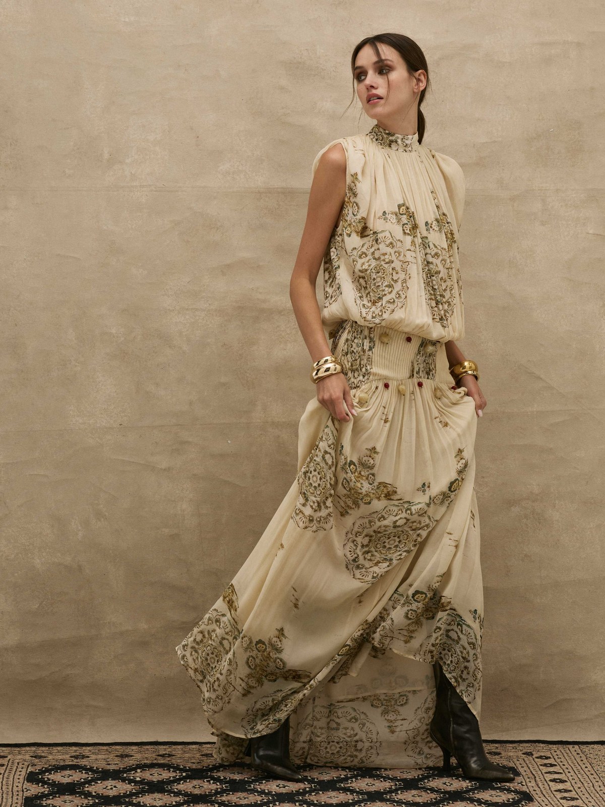 Model in an ivory printed maxi dress in a studio setting