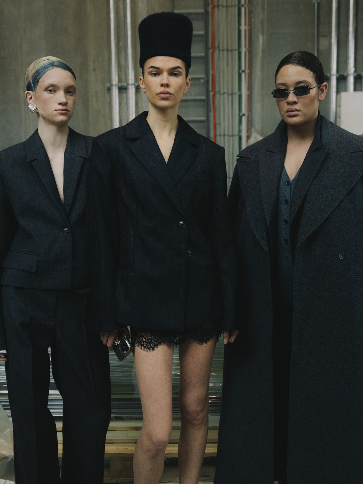 Three HERSKIND models in a checked blazer, cream slip, and beige vest