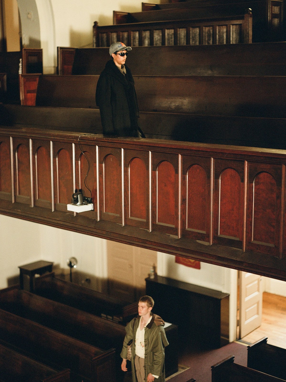 Models in layered coats inside a wood-paneled church