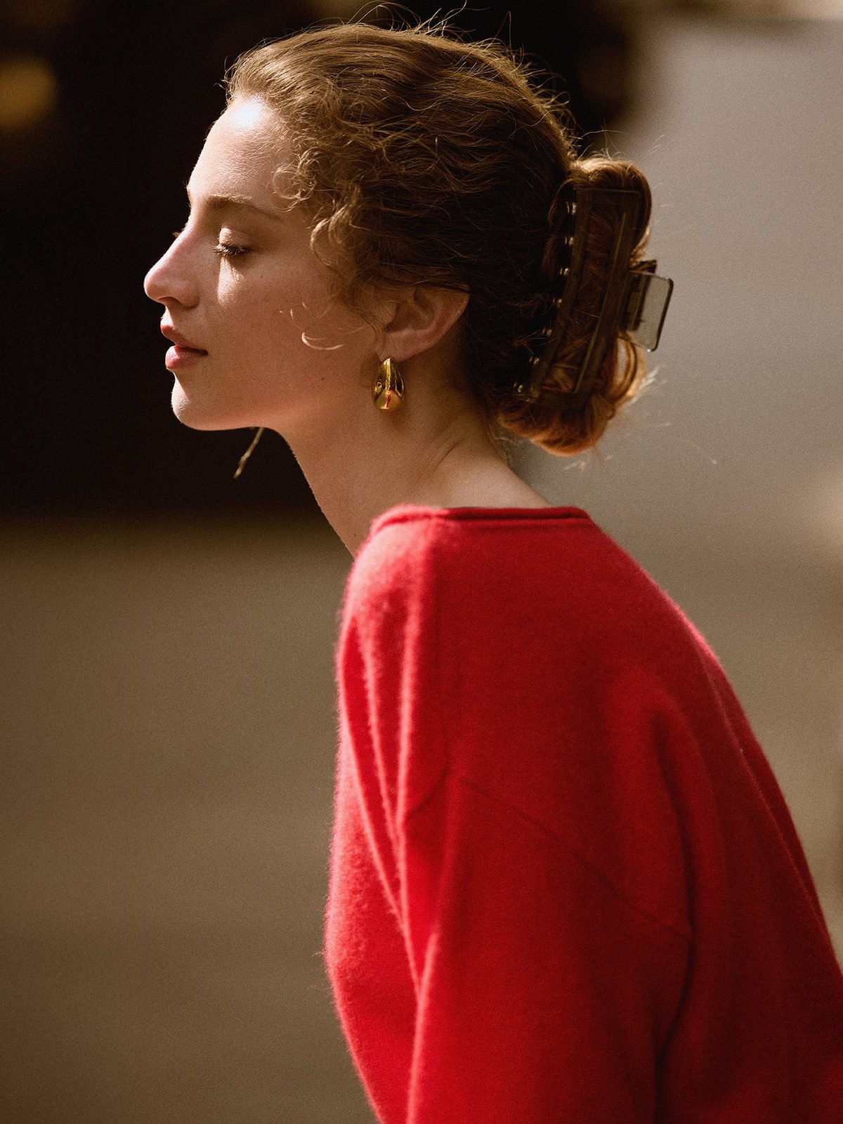 Model in a red sweater, shown in profile.
