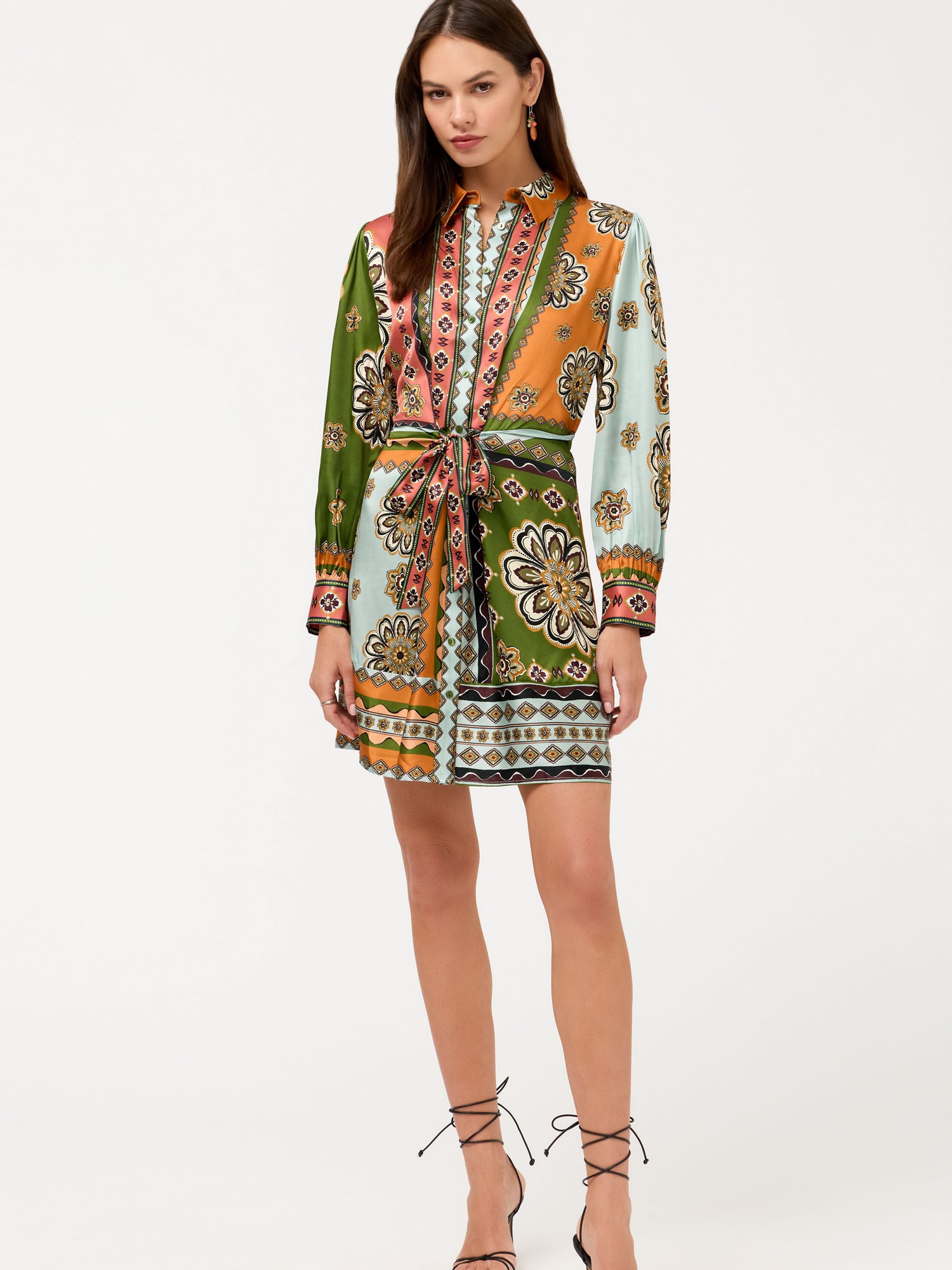 Model in a green and orange printed belted mini dress with lace up heels