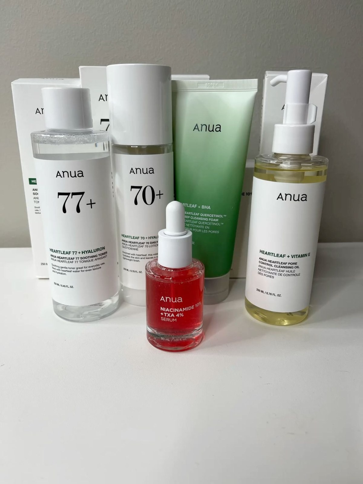 Anua toners, a red niacinamide serum and a cleansing oil lined up together