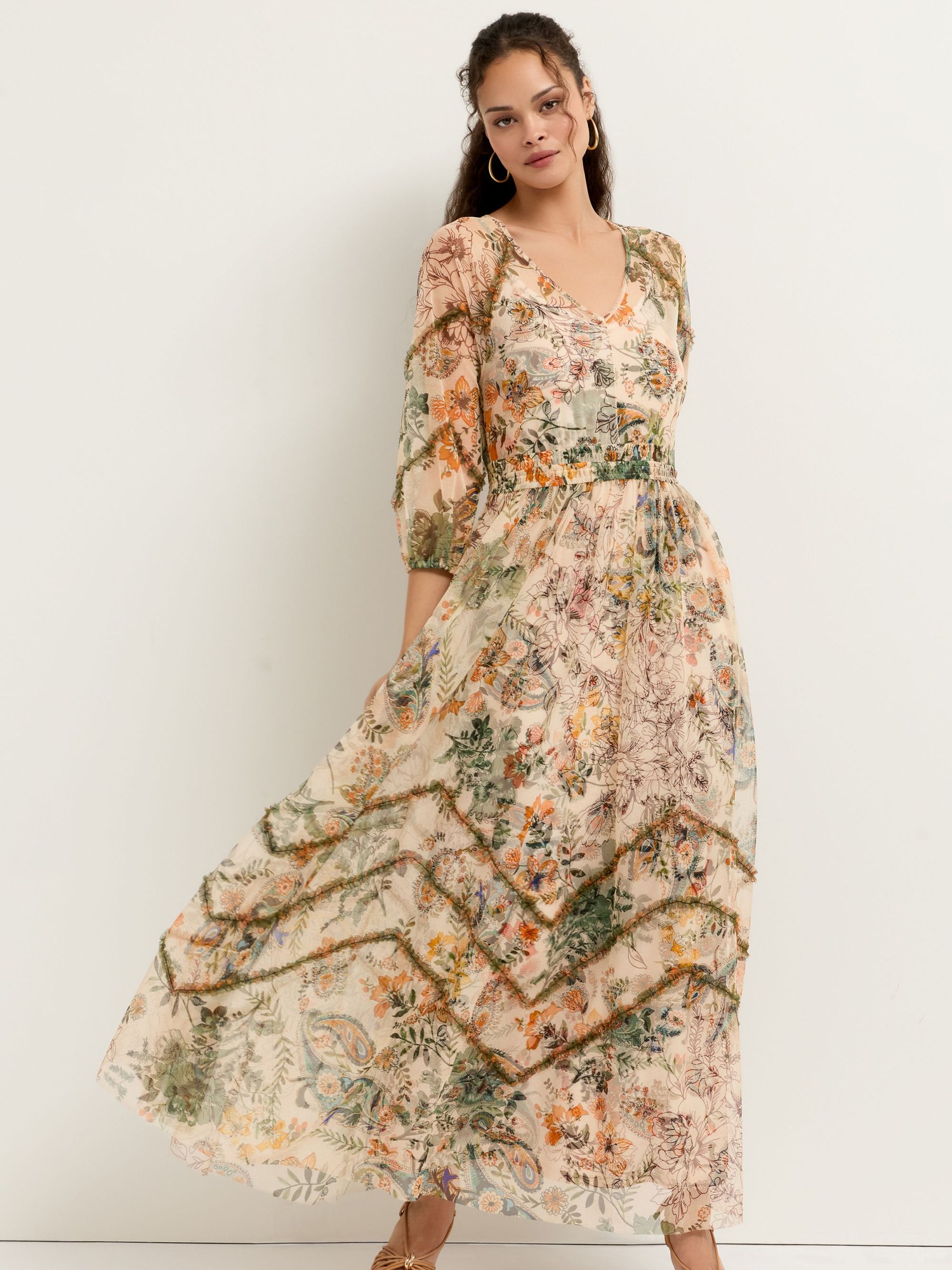 Model in a floral beige maxi dress with a full skirt