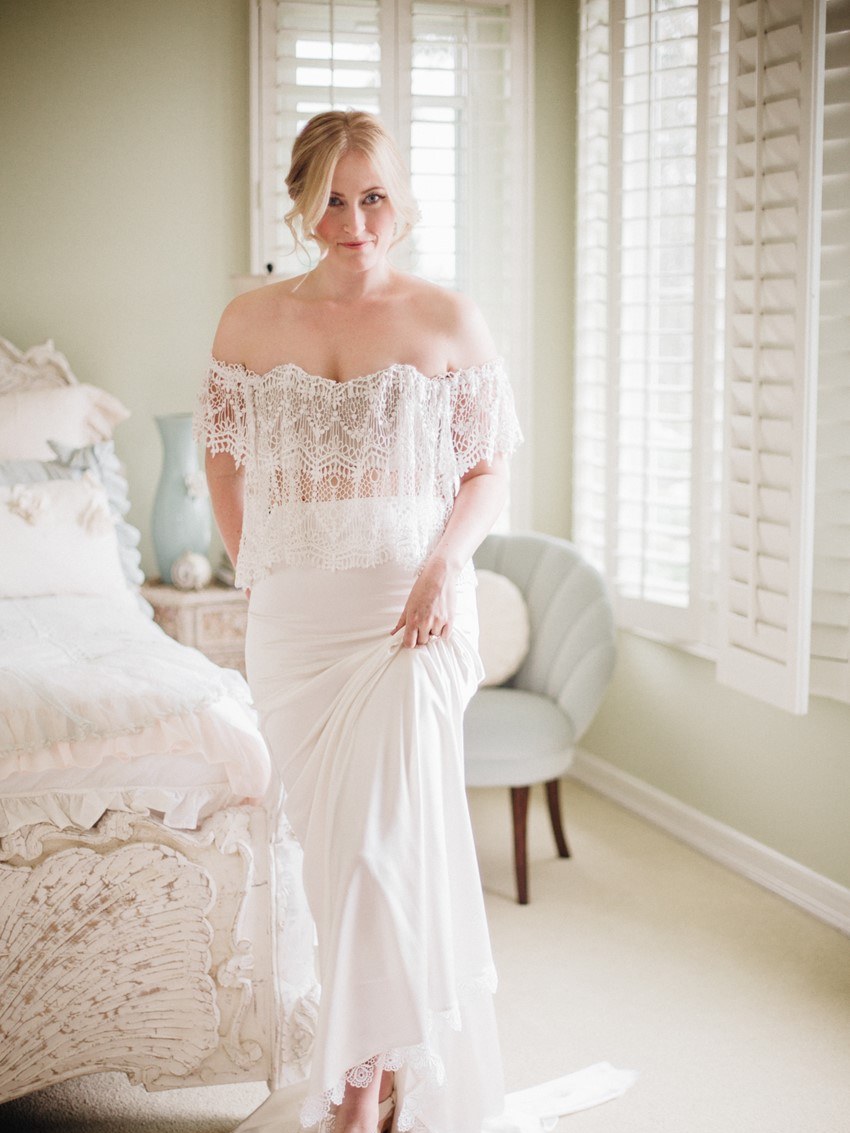 Bride in an off-shoulder Stone Cold Fox lace two-piece in a bright bedroom