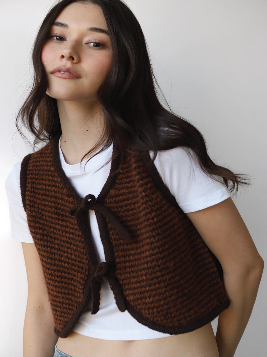 Model wearing a striped Callahan vest over a white tee