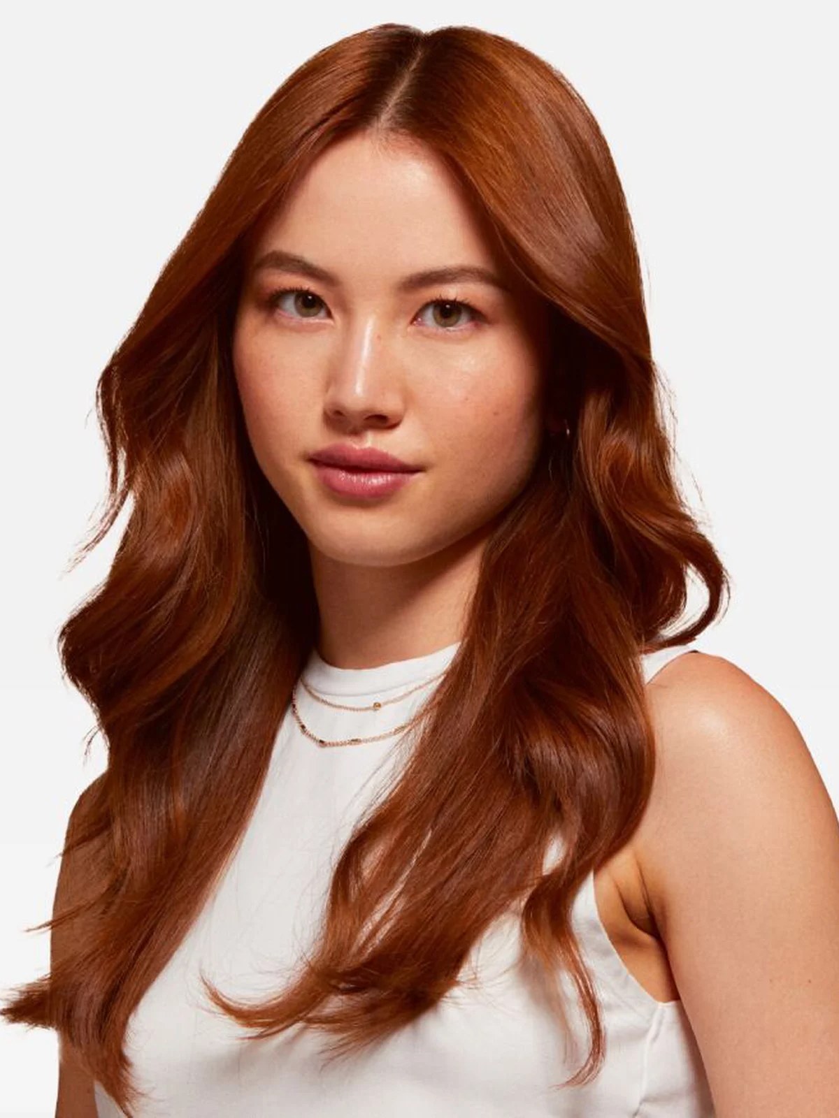 Model with long wavy copper red hair in a white top