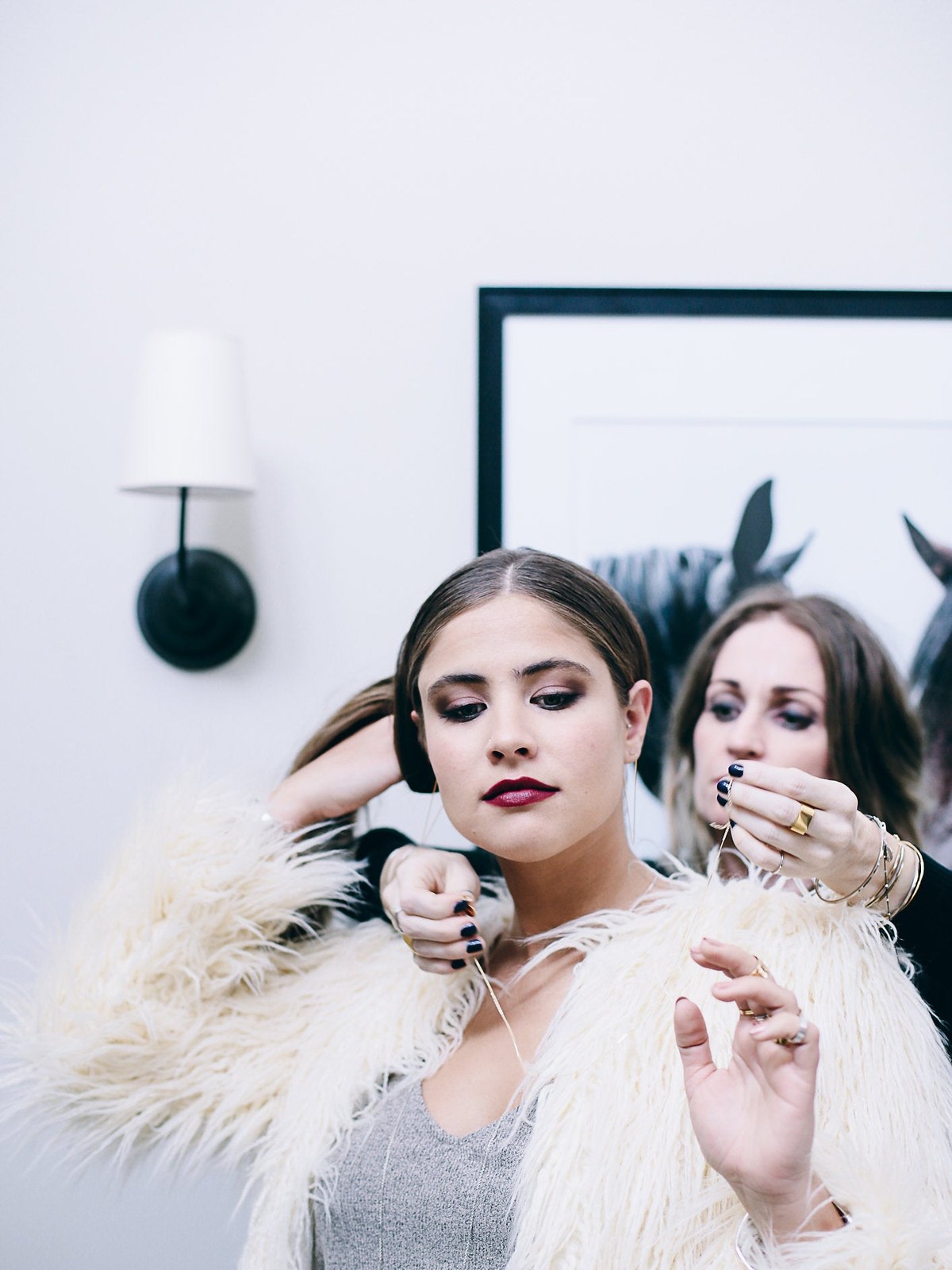 Model in a studio as a stylist arranges her hair for a jewelry shoot