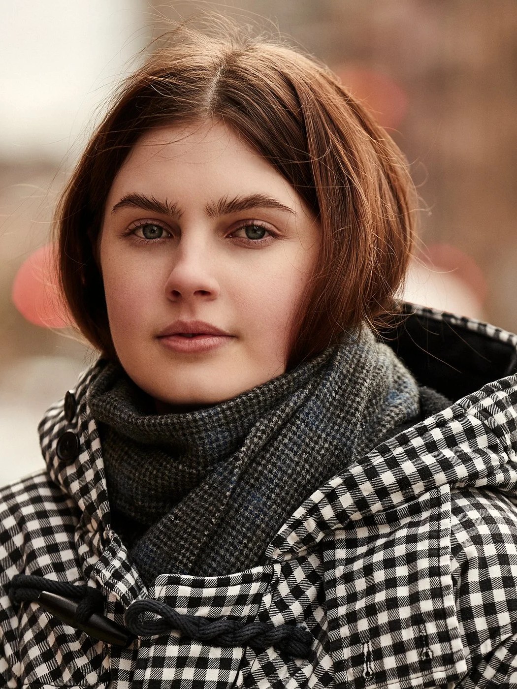 Close portrait of a model in a checked coat and scarf in the Denimist Fall Winter campaign