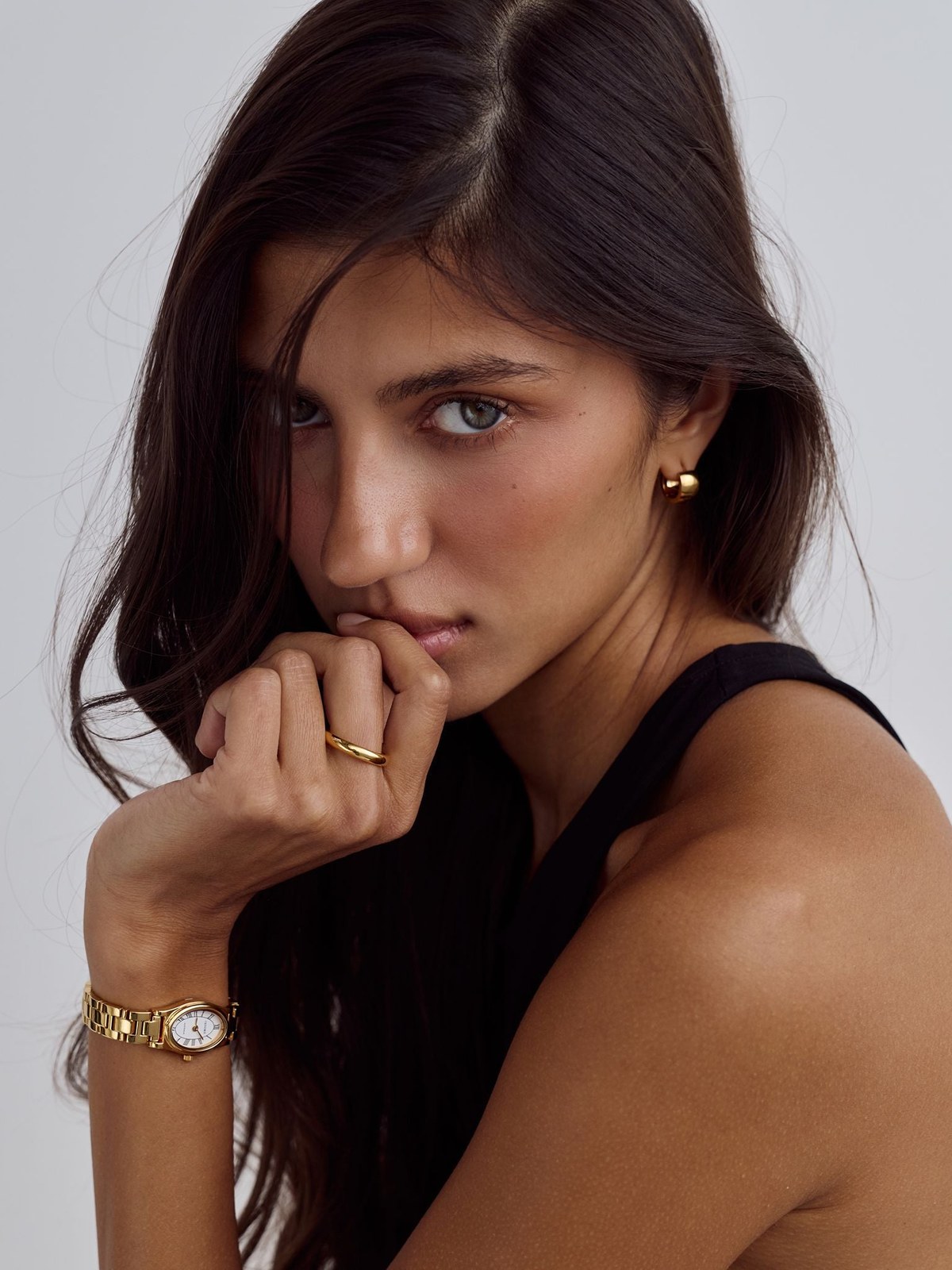 Model in a black sleeveless look wearing a Cendré watch in a softly lit studio