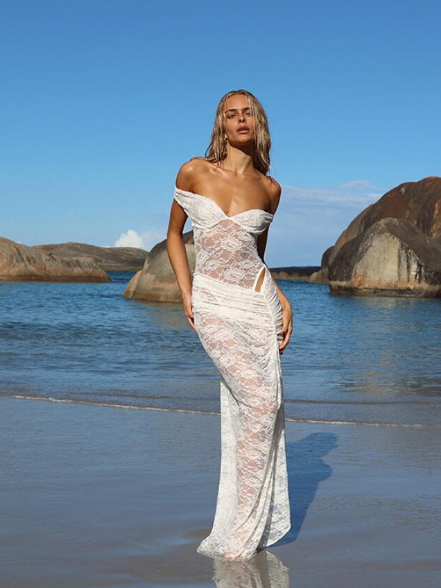 Model in a lace gown at a rocky shoreline