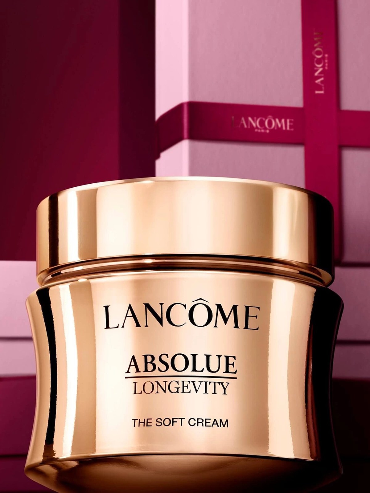 Gold lidded Absolue Longevity soft cream jar among burgundy and pink gift boxes