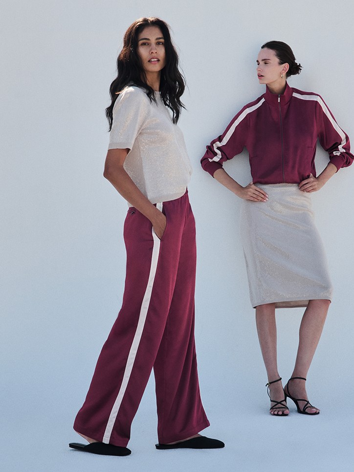 Two models in plum and ivory looks against a rooftop lookbook backdrop