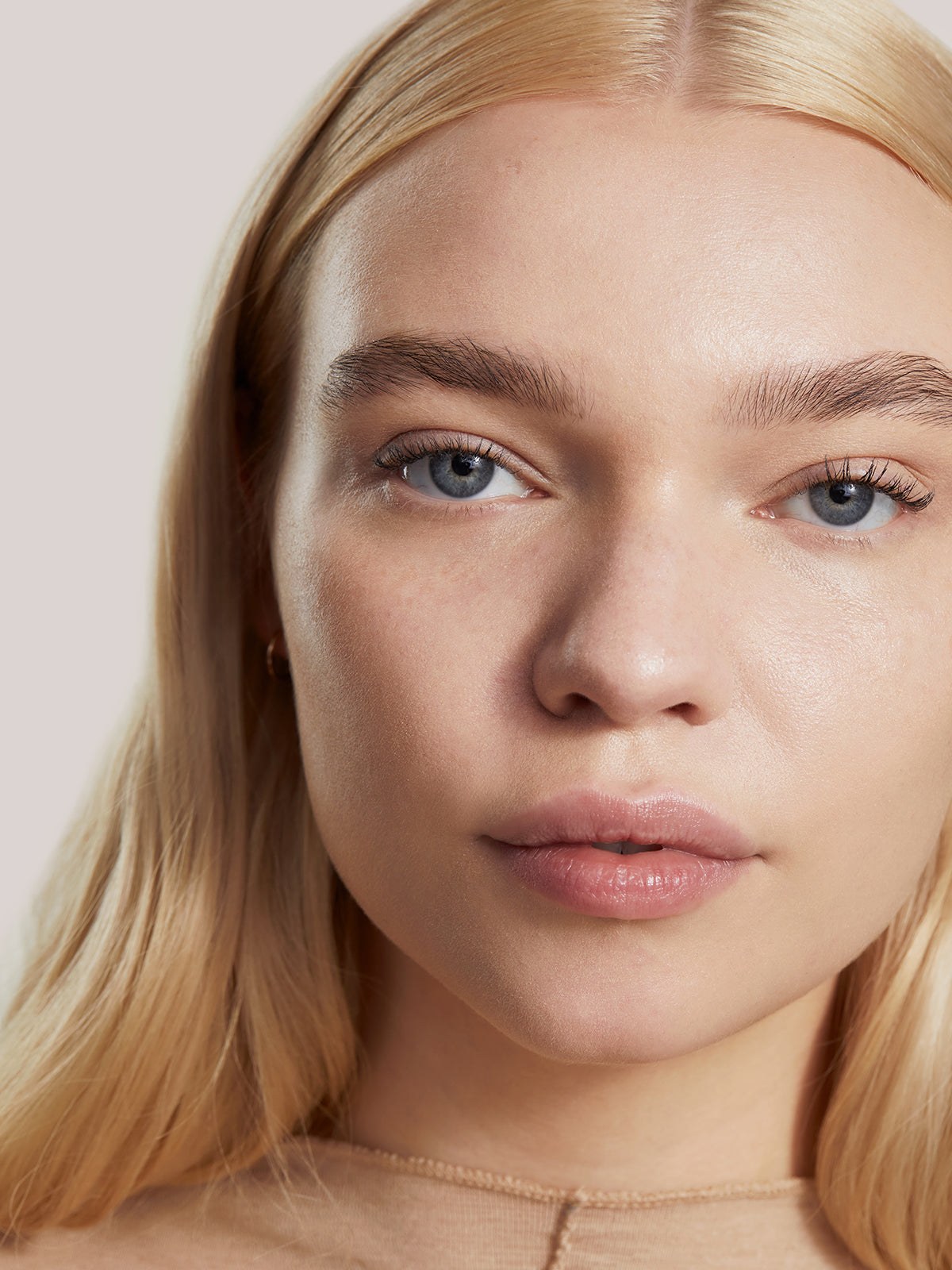 Close portrait of a blonde model with a natural skin tint finish
