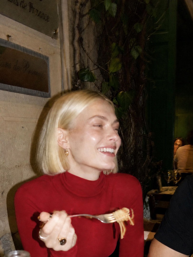 Woman in a red knit top at dinner