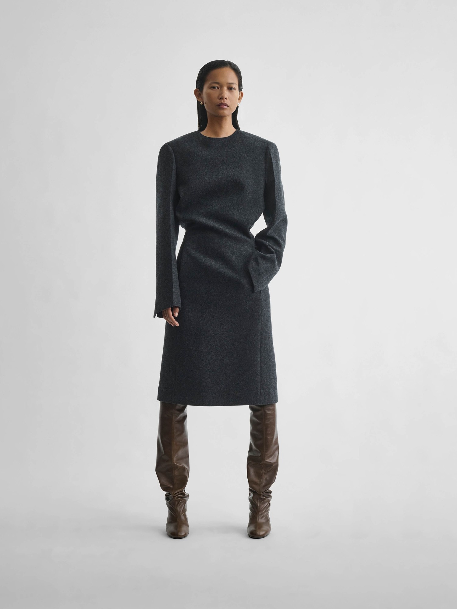 Model in an anthracite wool cashmere tailored dress with brown knee boots