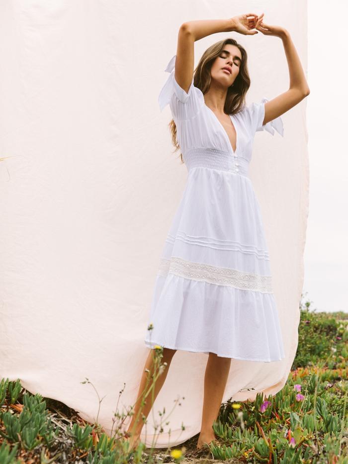 Woman in a white dress in a sunlit garden setting