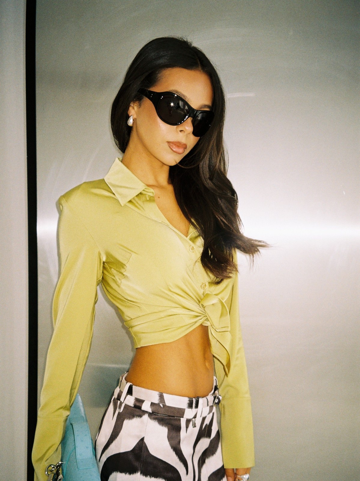 Model in a pale yellow tied blouse and graphic black-and-white trousers