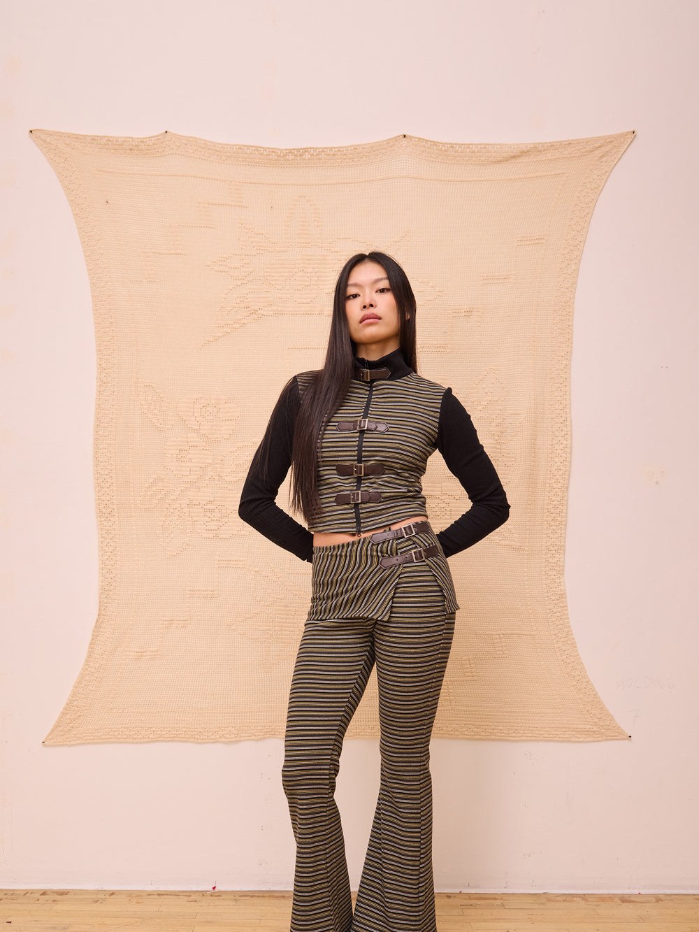 Model in a striped knit top and matching flared trousers