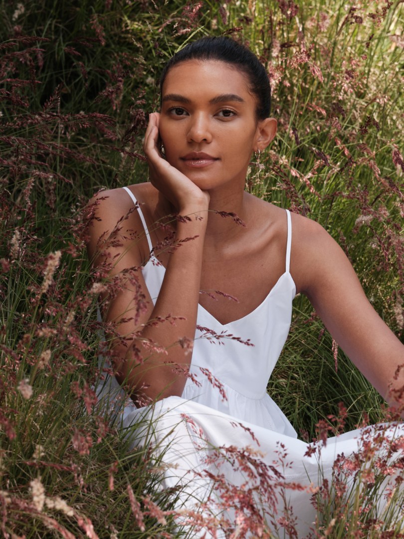 Model standing in flowering grasses