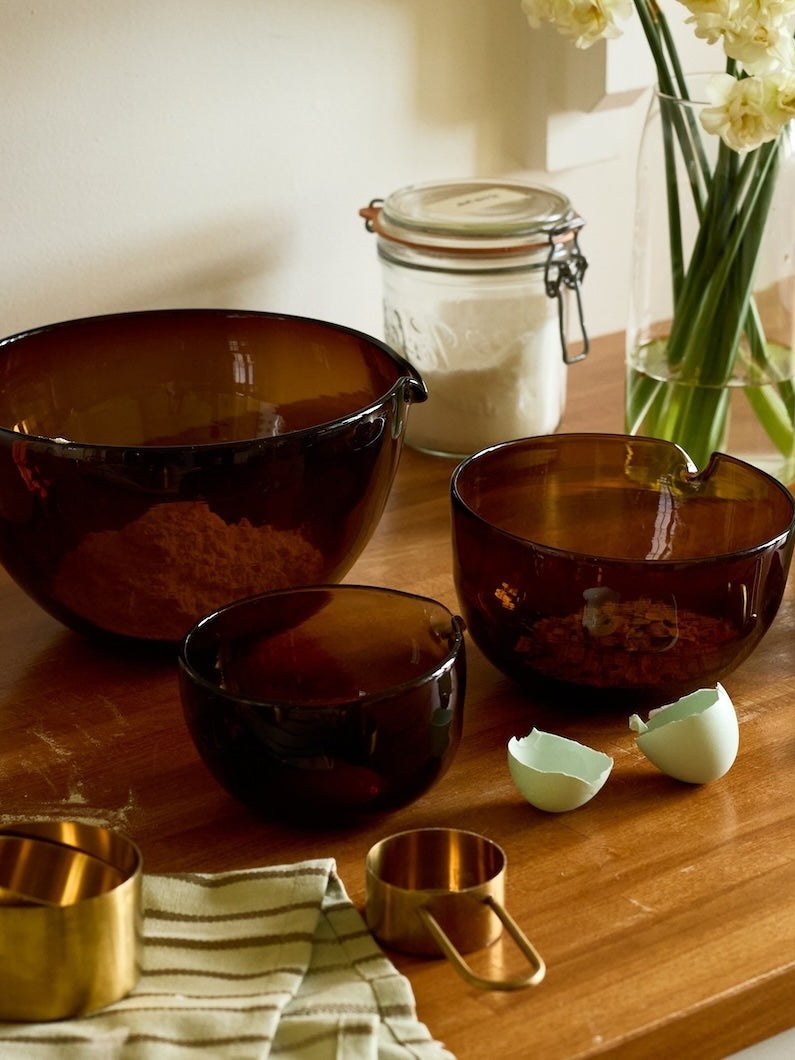 Brown glass bowls and cooking vessels on a wooden kitchen counter