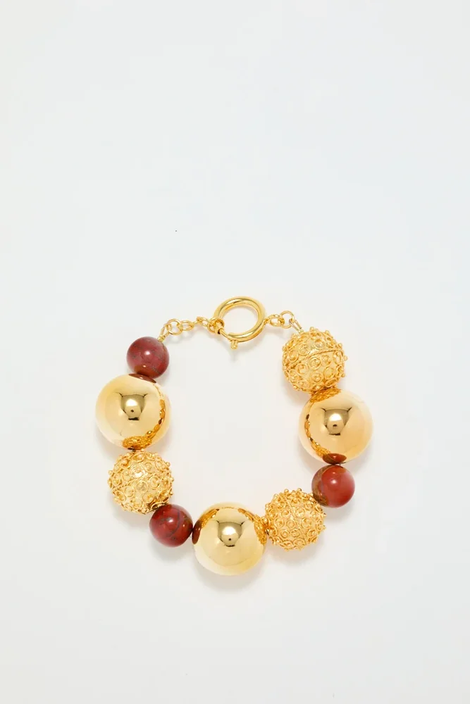 Gold bracelet with red pearl detail